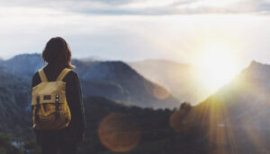 Woman with backpack looking at mountain range