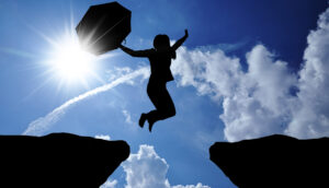 Woman jumping between cliffs
