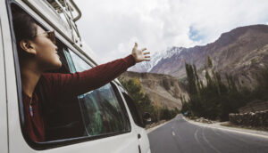 Woman driving through the mountains in a van