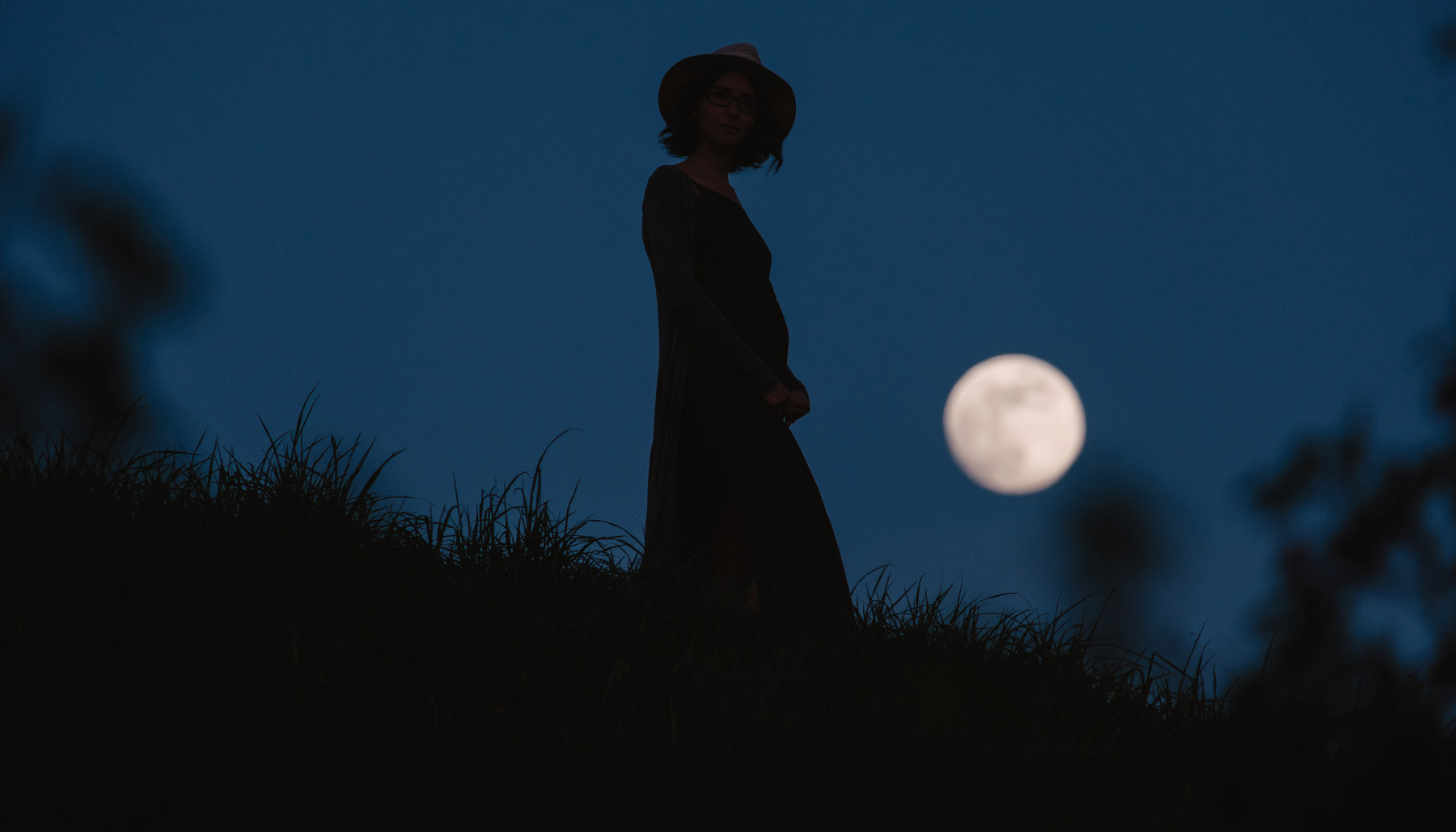 Woman in front of full moon